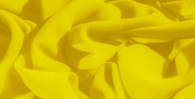 Yumuşak, organik kıvrımlı bulanık sarı kumaş çarpıcı bir görüntü yaratır. Kumaşın pürüzsüz, dokulu yüzeyi ışığı yakalar ve parçaya canlı ve dinamik bir enerji verir..