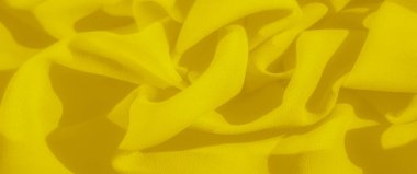 Görüntü, sarı kumaştan oluşan yumuşak ve narin bir düzendir. Soyut bir ışık ve gölge deseni oluşturur. Canlı renk ve pürüzsüz doku akış tasarımına derinlik ekler.