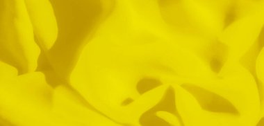 Yumuşak, narin kıvrımlarla çağlayan pürüzsüz, dalgalı sarı kumaşı bulanıklaştır. Canlı sarı tonlar, yüzeye sıcaklık ve parlaklığı getiren doku ve hareketin soyut bir görüntüsünü oluşturur..