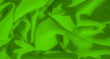 Yumuşak dalgalanmalar ve pürüzsüz dokularla kaplı parlak yeşil kumaştan oluşan bulanık bir görüntü, hafif röfleler ve gölgelerle dinamik, akıcı bir form yaratarak, maddenin esnekliğini vurguluyor..