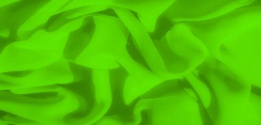 Parlak yeşil desenli sıvı ve organik katlarla sıralanmış kumaş bulanıklığı. Doğal örtüler kumaşların zengin yüzey dokusunu sergiliyor, sanatsal ve canlı bir görsel etki yaratıyor..