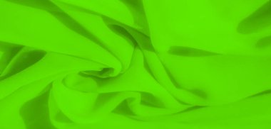 Yumuşak, örtülü yeşil bir kumaşın bulanık görüntüsü. Bu kıvrımlar ışık ve gölgenin dinamik bir etkileşimini yaratıyor, düz dokusunu ve canlı rengini vurguluyor..