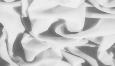 Gri kumaşın yumuşak kıvrımlarında oynayan bulanık ışık ve gölgeler. Kırışıklıklar ve pürüzsüz doku zarif ve minimalist bir soyut tasarım yaratır..