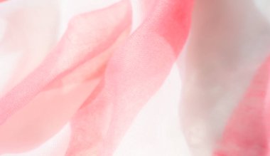 Bulanık pembe ve beyaz kumaş kıvrımları hassas kıvrımlar ve dalgalar oluşturarak iki ton arasındaki ince dokuyu ve nazik kontrastı vurguluyor..