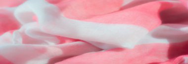 Yumuşak pembe ve beyaz kumaşların bulanık kıvrımları, ışık ve renklerin etkileşimini arttıran sıvı ve dalgalı bir doku oluşturarak hassas ve zarif bir tekstil bileşimi oluşturur..