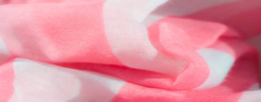 Yumuşak beyaz ve pembe kumaştan ince kıvrımlı bulanık, iki ton arasındaki zıtlığı vurguluyor. Kumaş, yumuşak bir akış ve sıcaklık uyandıran havadar ve hafif bir atmosfer yaratıyor..