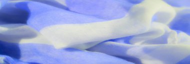 Mavi ve beyaz kumaşın yumuşak kıvrımları huzur verici bir desen oluşturur. Maddenin hassas dokusu canlı renklerle çelişiyor ve tasarım projeleri için rahatlatıcı bir görsel deneyim sunuyor..