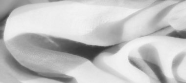 Bulanık gri kumaş ışık ve gölge zıtlıkları ile kıvrılır. Soyut bileşim, maddenin hassas dokusunu vurgulayarak hareket ve akıcılık hissi yaratır..