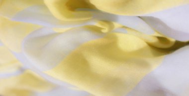 Sarı ve beyaz kumaşlardan oluşan bulanık kıvrımlar ince bir akışla yumuşak ve zarif bir doku oluşturuyor. Kumaşların şeffaf kalitesi hafif ışık etkileşimini arttırır..
