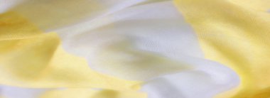 Yumuşak sarı ve beyaz kumaştan oluşan bulanık kıvrımlar akıcı ve pürüzsüz bir doku oluşturuyor. Işık, kumaşın hassas kıvrımlarını ve şeffaf kalitesini arttırır..