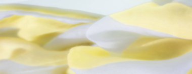 Yumuşak sarı ve beyaz kumaşlardan oluşan bulanık akıcı ve pürüzsüz bir dokuya sahip nazik kıvrımlar oluşturuyor. Işık, kumaşlara şeffaf bir kalite katıyor..