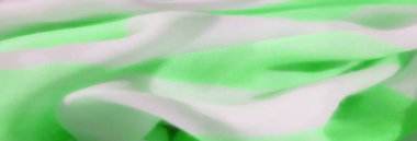 Pürüzsüz ve yumuşak kumaşın neon yeşil ve beyaz tonlarında ince bir doku ve hafif bir akış oluşturur..