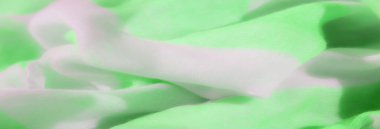 Yumuşak, neon yeşil ve beyaz kumaşlı, ince kıvrımlı ve nazik çizgili. Hassas dokusu pürüzsüz ve çağdaş bir tekstil görüntüsü veriyor..