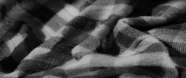 Gri tonlu yumuşak damalı kumaşın bulanıklığı pürüzsüz kıvrımları ve karmaşık dokuma detaylarını vurguluyor. Işık ve gölge arasındaki etkileşim, kumaşa derinlik ve dokunsal bir kalite ekler..