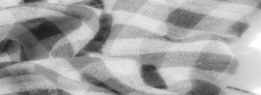 Gri tonlu yumuşak damalı kumaşın bulanıklığı pürüzsüz kıvrımları ve karmaşık dokuma detaylarını vurguluyor. Işık ve gölge arasındaki etkileşim, kumaşa derinlik ve dokunsal bir kalite ekler..