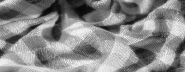 Gri tonlu kumaş, aydınlık ve karanlık denetimlerin karmaşık desenlerinde yumuşak, dokuma bir doku sergiliyor. Katlar derinlik yaratır, dokunsal kaliteyi arttırır.,