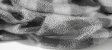 Yumuşak dokusu olan gri tonda katlanmış bir kumaşı bulanıklaştırın. Gri tonlardaki ışık ve gölgenin etkileşimi klasik ekose desenlere derinlik ve görsel ilgi katar..