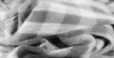 Görüntü. Yumuşak kıvrımlarla nazikçe örtülmüş gri pullu bir kumaş. Karmaşık dokusunu ve minimalist desenini gösteriyor..