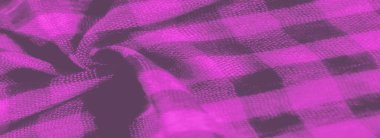 Yumuşak, desenli kumaş, canlı pembe ve siyah dama tahtası deseni, derinlik ve görsel hareket hissi yaratır. Yakın plan, kumaşların örgü ve kıvrımlarını vurgular, dokunsal bir kalite ekler.