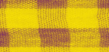 Yumuşak sarı kumaşın bulanık kıvrımları, akışkan dokular ve kareli bir görünüm ile soyut bir model oluşturur. Yakın plan, sıcak ve davetkar bir görsel efekt oluşturarak, karmaşık dokumayı vurgular.