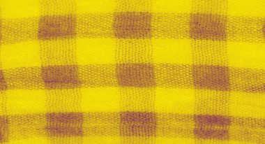 Yumuşak kıvrımları ve damalı desenleri olan dokulu sarı bir kumaşın bulanıklığı. Kumaş, ışık ve gölgenin ince zıtlıklarını gösterir ve tasarımda dinamik bir akış yaratır..