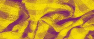 Yumuşak dalgaları ve kıvrımları olan dokulu sarı bir kumaşın bulanıklığı. Kalıplar, koyu tonlara karşı zengin sarı tonlara sahip kareli bir tasarımı gösteriyor. Kumaş pürüzsüz.