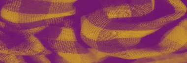 Yumuşak dalgaları ve kıvrımları olan dokulu sarı bir kumaşın bulanıklığı. Kalıplar, koyu tonlara karşı zengin sarı tonlara sahip kareli bir tasarımı gösteriyor..