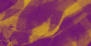 Kareli desenli sarı desenli kumaşın yakın plan görüntüsü. Yumuşak malzeme nazikçe katlanır, kumaşın karmaşık dokumasını ve parlak tonunu gösterir..