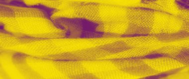 Katlanmış sarı kareli kumaşın bulanık dokusu ve yumuşak dokusu karışıktır. Sıcak, parlak sarı tonlar, hassas desenle görsel olarak çarpıcı bir kontrast oluşturur..