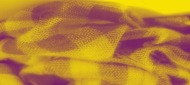 Katlanmış sarı kareli kumaşın bulanık dokusu ve yumuşak dokusu karışıktır. Sıcak, parlak sarı tonlar, hassas desenle görsel olarak çarpıcı bir kontrast oluşturur..