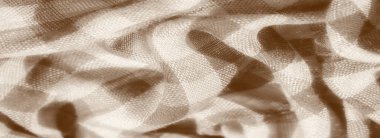 İnce ekose desenli ve sepya tonlu bir kumaşın bulanıklığı. Dokuma malzemesindeki karmaşık dokular ve yumuşak ışık yansımaları ona görünür detaylarla klasik, samimi bir cazibe veriyor..