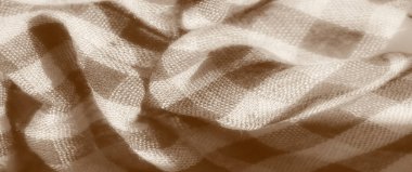 Yumuşak, desenli kumaş ve sepia tonlarında damalı desenler. Malzemenin hassas dokusu doğal kıvrımları ve kırışıklıklarıyla organik ve zamansız bir görünüm sağlar..