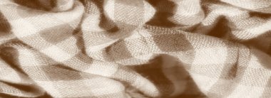 Kareli kumaşın, pürüzsüz bir akışla yakın plan görüntüsü, kumaşın karmaşık dokumasını gösteriyor. Sepya tonu, hassas kıvrımlar bir hareket hissi yaratarak, eski moda bir his katıyor.