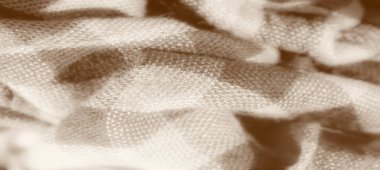 Kareli desenli kumaş bulanıklığı, derinlik ve gölge yaratmak için nazikçe katlanmış. Sedef tonlu tasarım maddenin pürüzsüzlüğünü ve yumuşak yapısını vurgular.