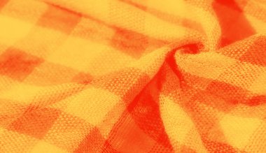 Kareli desenli turuncu ve sarı dokuma kumaşın bulanık görüntüsü. Doku ve kıvrımlar parlak tonlara derinlik katar, sıcak ve davetkar bir his yaratır. Arkaplan veya tekstil kavramları için ideal.