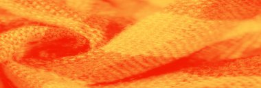 Bulanık turuncu ve sarı kumaşlı yumuşak desenli katlar. Sıcak, canlı renkler ve dokuma desenler döşeme, moda veya ev dekorasyonu projeleri için mükemmel bir ortam yaratıyor..