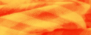 Yumuşak kıvrımlı, parlak sarı ve turuncu kareli kumaş ve zengin dokunun detaylı bir görüntüsü. Karmaşık dokuma ve kalın renkler bu kumaşı tasarım ve tekstil ilhamları için ideal hale getiriyor..