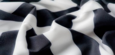 Görüntü. Bu seri yumuşak, akışkan siyah-beyaz çizgili kumaşı yumuşak kıvrımlarla yakalar, ipeksi dokusunu ve minimalist zarafetini vurgular. Yumuşak kıvrımlar dinamik bir karşıtlık yaratır