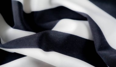 Dinamik kıvrımlarda siyah beyaz çizgili bulanık bir kumaş. Kalın çizgiler ve yumuşak dokular arasındaki çarpıcı tezat görsel ve şık bir tekstil tasarımı yaratır..
