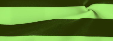 Pürüzsüz kıvrımlar halinde akan yeşil ve koyu renkli çizgiler dinamik kontrast ve madde boyunca nazik dalgalarla dokulu bir kumaş görünümü yaratıyor..