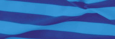 Bulanık mavi kumaş katmanları koyu lacivert çizgilerle örülmüş. Yumuşak ve dalgalı bir şablonla karışıyor. Canlı karşıtlık derinlik katıyor