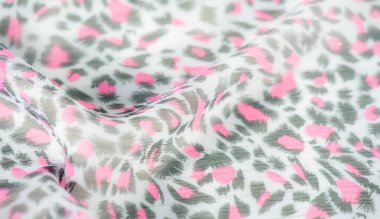 Karmaşık kumaş tasarımı, şeffaf gri bir ağ üzerinde koyu yeşil yaprak benzeri desenlere karşı parlak pembe detaylar gösteriyor. Bu canlı zıtlık kumaşa dinamik bir görünüm verir.