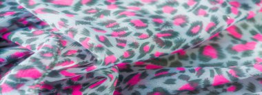 Pembe ve koyu yeşil motifli havadar kumaş bulanıklığı, canlı bir desen oluşturuyor. Bu hassas malzeme ışığı yakalar ve tasarım için ideal derinlik ve doku ekler..