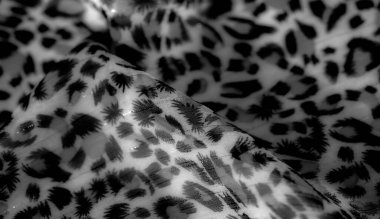 Görüntü. Yumuşak, karmaşık desenli gri tonda ve akışkan siyah tasarımlı kumaş. Işık yansımaları zengin bir doku yaratır, arka plan, tekstil veya yaratıcı projeler için mükemmeldir..