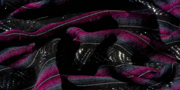 Kumaşın siyah, morumsu ve mavinin dinamik karışımını bulanıklaştırarak parlak röflelerle soyut bir kompozisyon oluşturur. Işık ve dokunun etkileşimi bu tekstil için lüks bir cazibe sağlar..