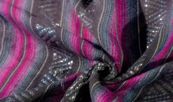 Siyah kumaşa karşı mor ve mavinin canlı çizgilerini bulanıklaştır. Tekstil boyunca parıldayan elementler kumaşa derinlik katarak sanatsal ve soyut bir görünüm veriyor..