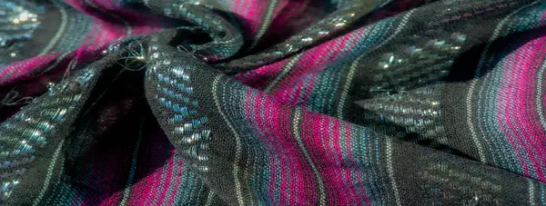Parlak pembe ve mor çizgileri olan siyah bir kumaşın bulanıklığı. Titreyen aksanlar, kıvrımların hareketini ve derinliğini karmaşık detaylarla yakalıyor..