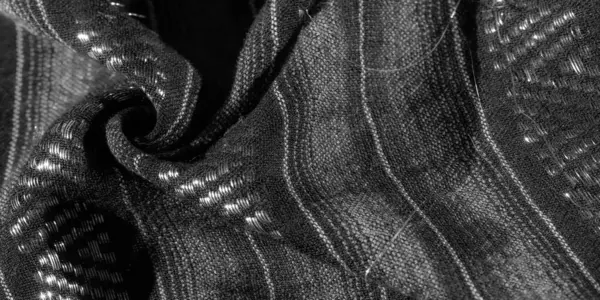 Dokuma dokusunun yakın görüntüsü ince dokuma dokuları ve yansıtıcı elementleri olan tek renkli siyah bir desen içerir. Parlak ve zarif bir görsel oluşturur..