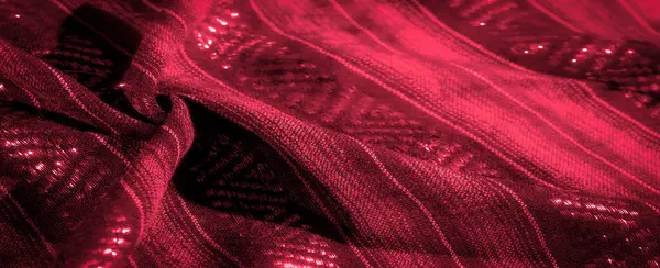 Parlak kırmızı kumaş, dokuma dokular ve parlak röfleler. Kumaşın yumuşak örtüsü ve karmaşık desenleri zarafetini ve lüksünü gösteriyor..