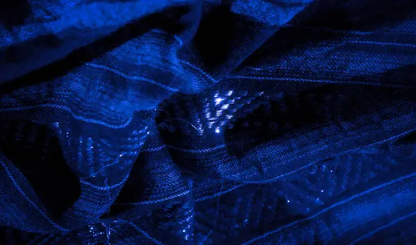 Bu mavi kumaşın parlak dokusu ve karmaşık dokusu büyüleyici ve katmanlı bir görünüm yaratır. Işıldayan ipliklerle vurgulanan kumaş, derinliği ve hareketi çağrıştırıyor.,
